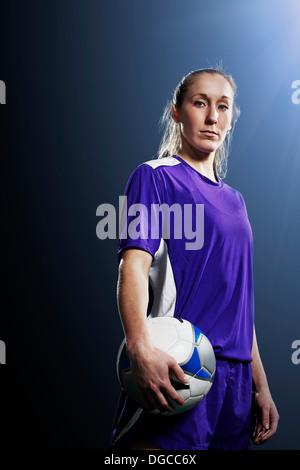 Studio shot di giovani femmine soccer giocatore in possesso palla Foto Stock