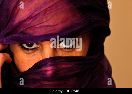 Primo piano di un misterioso donna marocchina con un velo di colore viola o sciarpa oltre il suo volto a Essaouira, Marocco Foto Stock