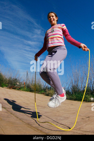 Una ragazzina salta una corda. Foto Stock