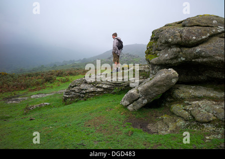 Un escursionista sulle rocce Bonehill, Dartmoor Devon UK Foto Stock