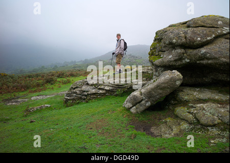 Un escursionista sulle rocce Bonehill, Dartmoor Devon UK Foto Stock