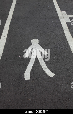 Cartello bianco che indica un passaggio pedonale dipinta su una strada in corrispondenza di una stazione di servizio Foto Stock