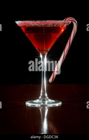 Holiday martini servito su uno sfondo scuro con un candy cane guarnire, girato con un filtro a stella Foto Stock