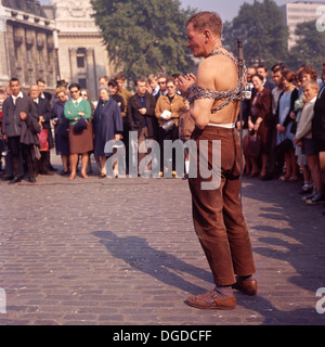 Anni '1960, storico, artista di fuga maschile, evapologo o intrattenitore di strada si esibisce di fronte a una folla all'ora di pranzo a Tower Hill, Londra, EC3, Inghilterra, Regno Unito. Foto Stock