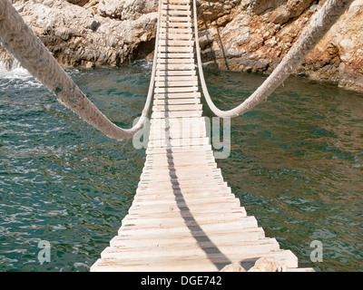 Appendere il ponte di legno collegare Mare roccioso-costo Foto Stock