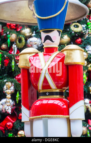 Close up su una tavola di legno schiaccianoci con uno sfondo di albero di Natale e ornamenti Foto Stock