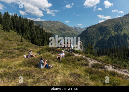 Un piccolo gruppo di escursionisti per adulti facendo una breve sosta per un pic-nic lungo il Madrisa a Klosters trail. Svizzera Foto Stock