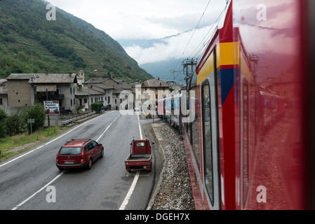 Bernina Express Treno in avvicinamento a Tirano stazione sul confine italiano. Ferrovia Retica. Foto Stock