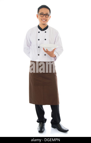 Corpo pieno chef asiatico tenendo una piastra vuota, in piedi isolato su sfondo bianco. Foto Stock