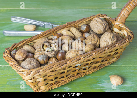 Un assortimento di dadi in un cestino sul tavolo di legno Foto Stock