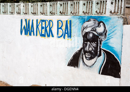 Dipinto sul muro di una zona residenziale composto indicante che il residente aderisce ad un particolare capo religioso musulmano. Gambia. Foto Stock