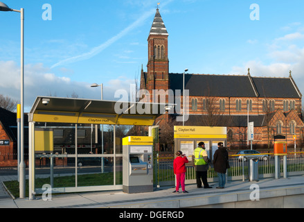 A Clayton Hall Metrolink fermata del tram, East Manchester Linea, Clayton, Manchester, Inghilterra, Regno Unito. Chiesa di Santa Croce dietro. Foto Stock