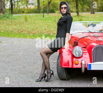 La donna in nero con occhiali scuri con auto Foto Stock