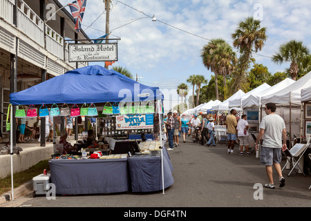 Visitatori Cedar Key Seafood arti e mestieri festival con borse a mano in un distributore in stallo di fronte Island Hotel. Foto Stock