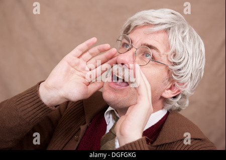 Capelli grigi uomo vecchio con le sue mani a gridare forte. Foto Stock