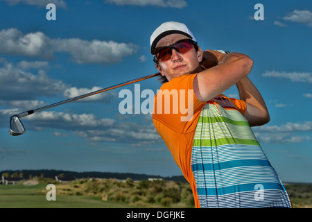 Il Golfer gioca un tiro di ferro durante il suo giro Foto Stock