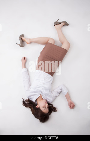 Un business donna sdraiata sul pavimento Foto Stock
