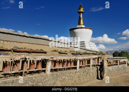 Pellegrino tibetano la filatura ruote della preghiera al di fuori delle mura del monastero Tashilhunpo, Shigatse, nel Tibet, Cina, Asia Foto Stock