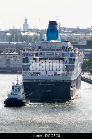 La nave di crociera 'Saga Sapphire' essendo tirato in allontanamento dal terminal crociere dal rimorchiatore, a Stoccolma in Svezia. Foto Stock