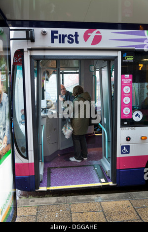 Parlando del passeggero al conducente sul primo bus pubblico presso la fermata degli autobus. Foto Stock