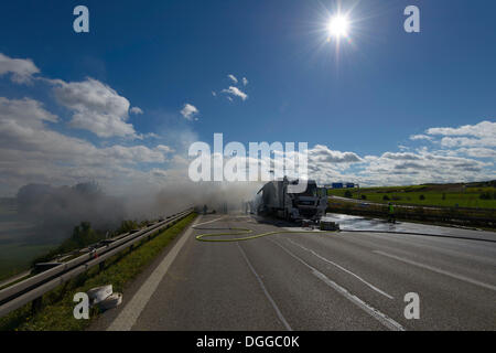 I vigili del fuoco spegnere un incendio del carrello sulla autostrada A8 vicino al 'Echterdinger Ei' junction, Stoccarda, Baden-Wuerttemberg Foto Stock