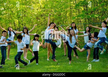 Un folto gruppo di bambini in ballo nel parco Foto Stock