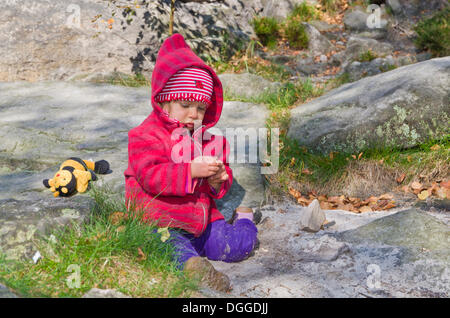 Bambina a giocare tra le rocce in sabbia, Ostrov, Repubblica Ceca, Europa Foto Stock