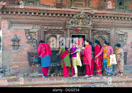 Accodamento delle donne di fare offerte a un tempio su Patan Durbar Square, Patan, Lalitpur District, zona di Bagmati, Nepal Foto Stock