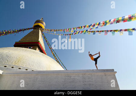 Giovane donna a praticare yoga a Boudnanath stupa, mostrando il Natarajasana pongono, o Signore Shiva posa, Valle di Kathmandu Foto Stock