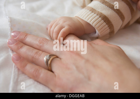 Baby boy azienda madre la mano, close up Foto Stock