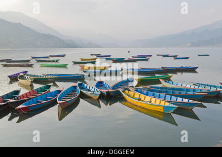 Barche colorate sul lago Phewa, colline e nuvole nel retro, Pokhara, Nepal Foto Stock