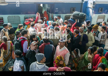 Una folla di gente che spinge all'interno di un treno su una piattaforma della stazione ferroviaria di Allahabad, Uttar Pradesh, India Foto Stock