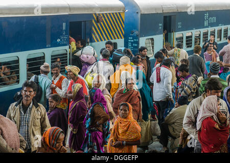 Una folla di gente che spinge all'interno di un treno su una piattaforma della stazione ferroviaria di Allahabad, Uttar Pradesh, India Foto Stock