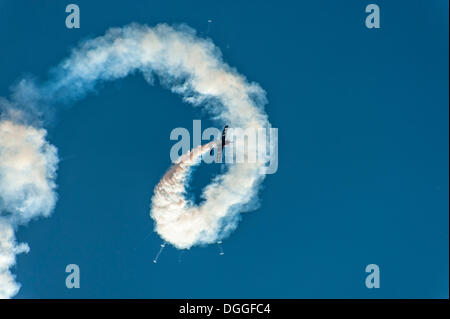 Volo acrobatico con un Extra 300S aeromobili con fumo nel cielo blu, Grevenbroich, Renania settentrionale-Vestfalia Foto Stock