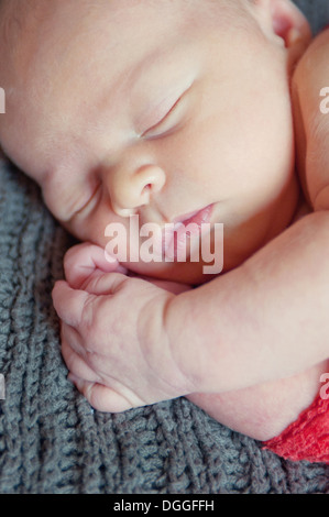 Bambino giacente sulla coperta grigio, dormendo Foto Stock