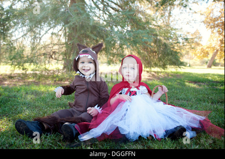 Il Toddler gemelli nel bosco vestito come Cappuccetto rosso e il lupo Foto Stock