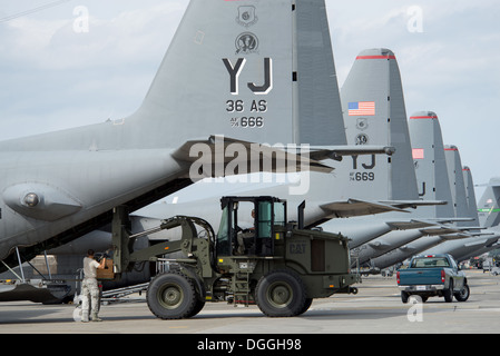 Avieri dal 374 disponibilità logistica squadrone di mobilità di combattimento carico di volo a basso costo e bassa altitudine bundle di carico su un C-130 Hercules al Yokota Air Base, Giappone, Ottobre 8, 2013. Avieri dal 374 LRS mantenere e preparare il carico dell'antenna sistema di consegna Foto Stock