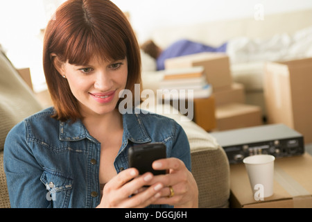 La donna gli sms sul cellulare mentre casa in movimento Foto Stock