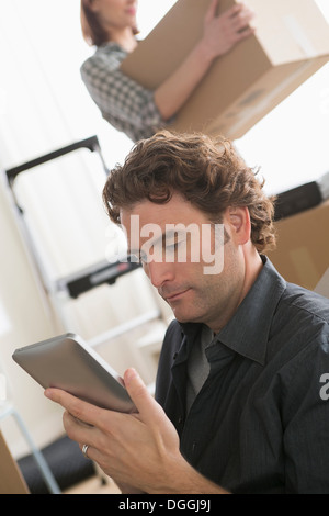 Uomo che guarda a tavoletta digitale mentre si sposta home Foto Stock