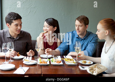 Quattro amici di mangiare il cibo del ristorante Foto Stock