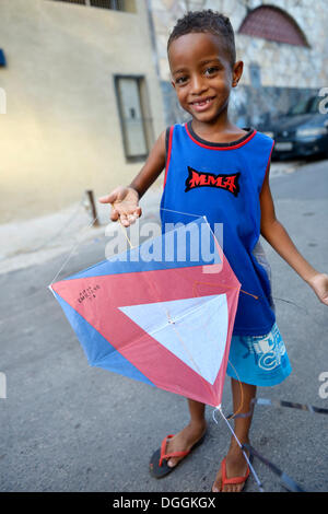 Ragazzo giovane tenendo un kite in una delle baraccopoli o favela, Jacarezinho favela, Rio de Janeiro, Stato di Rio de Janeiro, Brasile Foto Stock