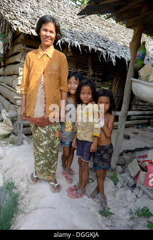 Donna con tre ragazze di fronte una capanna di legno e paglia, Trapang Village, Bathi Distretto, Provincia di Takéo Foto Stock