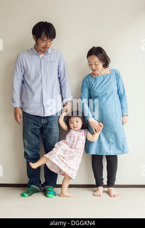 I genitori tenendo la figlia con le mani in mano, ritratto Foto Stock