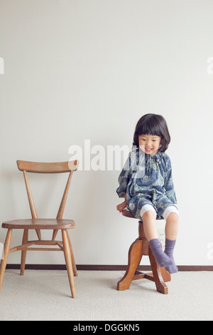 Ragazza seduta su uno sgabello, ritratto Foto Stock