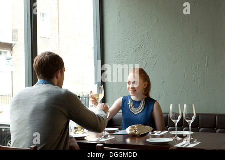 Coppia giovane nel ristorante La tostatura bicchieri di vino Foto Stock