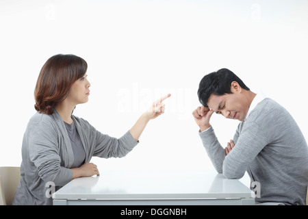 Un uomo e una donna seduta a un tavolo sostenendo Foto Stock