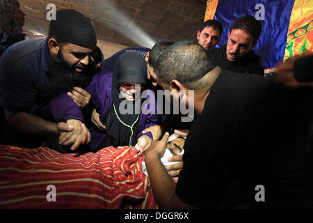 Betlemme, West Bank, Territorio palestinese . Xxi oct, 2013. Parenti palestinese di Younis al-Radaideh piangere sopra il suo corpo durante il suo funerale nel villaggio Ubiedyeh vicino al West Bank città di Betlemme, Ottobre 21, 2013. Forze israeliane giovedì sparato e ucciso Younis Radaideh Ahmed, 28, dopo che egli è stato guidato un trattore in una base militare a nord di Gerusalemme, secondo la media israeliani e un ufficiale militare Credito: Issam Rimawi APA/images/ZUMAPRESS.com/Alamy Live News Foto Stock