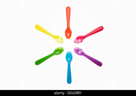 In plastica colorata cucchiai in un cerchio Foto Stock