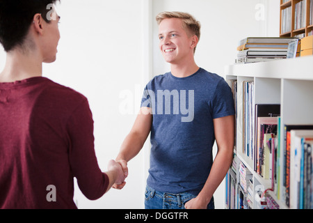 Due giovani uomini stringono le mani Foto Stock