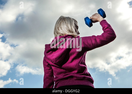 Giovane donna utilizzando i pesi a mano Foto Stock